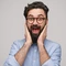 Un homme barbu étonné avec des lunettes